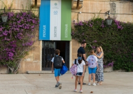 Una família amb infants és rebuda a l’entrada de l’Escola Garbí Pere Vergés de Badalona